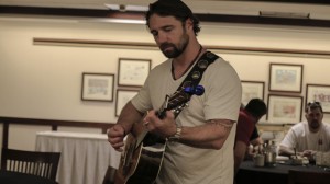 Former Navy SEAL and recording artist Pete Scobell warms up before playing three songs -- including his hit "Hearts I Left Behind" -- Saturday at the Hotel Pattee. ThePerryNews photo by Mark Summerson.