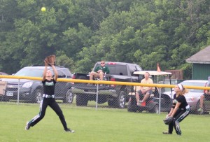 Center fielder Bree Lesch runs under a fly ball as right fielder Josie Baumgartner backs up the play.
