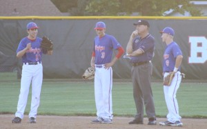 Perry infielders Alexis Garrido (13), Alex Long (3) and Nic Wilhelmi (9) share a light moment with the base umpire during a pitching change in the fifth inning.