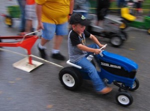 Five-year-old Harry McClure of Dallas Center drove on through the rain in the pedal-power tractor pull at the Dallas Center Fall Festival. Photo courtesy DC Celebrations