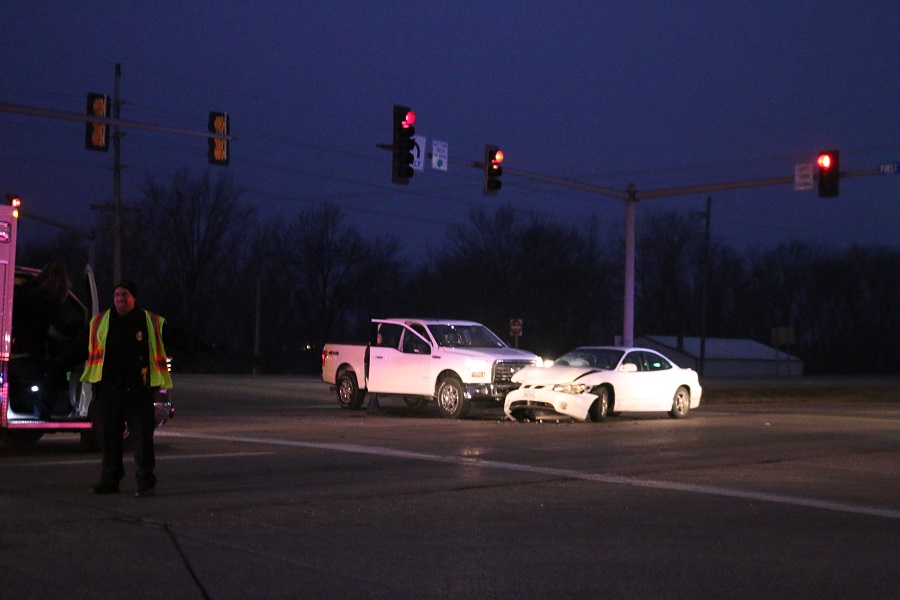Perry Police Det. Jerome Hill, left, directs westbound traffic on Iowa Highway 141 at First Avenue away from the scene of the two-vehicle collision.