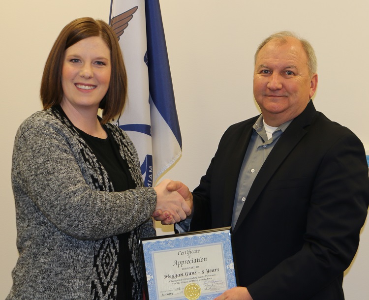 Meggan Guns, left, was thanked by Dallas County Attorney Wayne Reisetter for her five years of service.