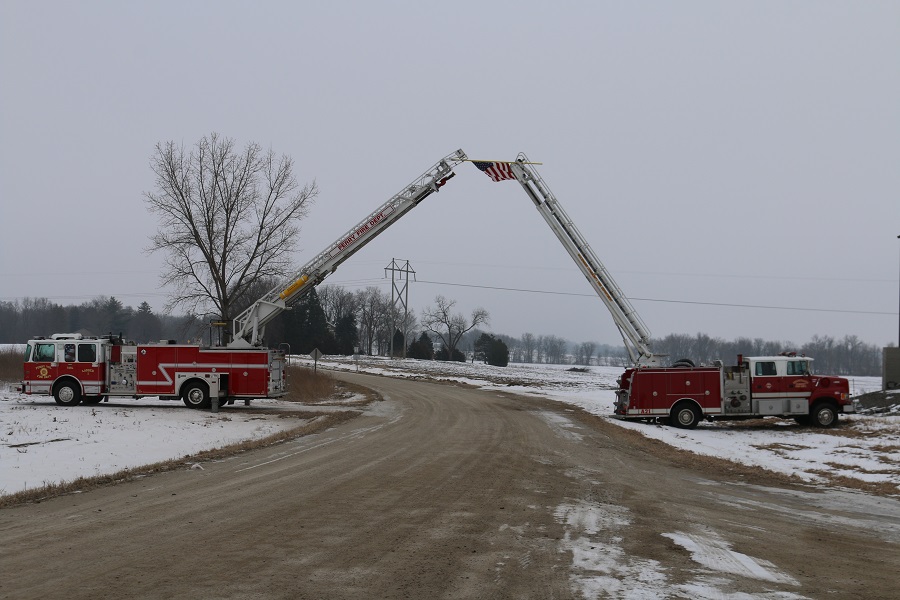 An arch of honor was erected Monday morning to mark the passing of the funeral cortege of Wilford Roberts of Perry, longtime benefactor to the town. Ladder trucks from the Perry Volunteer Fire Department and Woodward Volunteer Fire Department held a U.S. flag over the route to the Mowrer Cemetery.