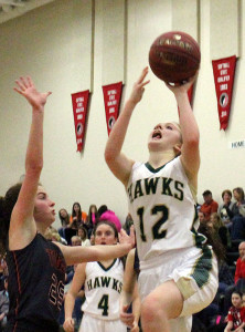 W-G forward Mary Hansen scores over the defense of Madrid's Rylan Santi Friday as Riley Jamison (4) follows the action.