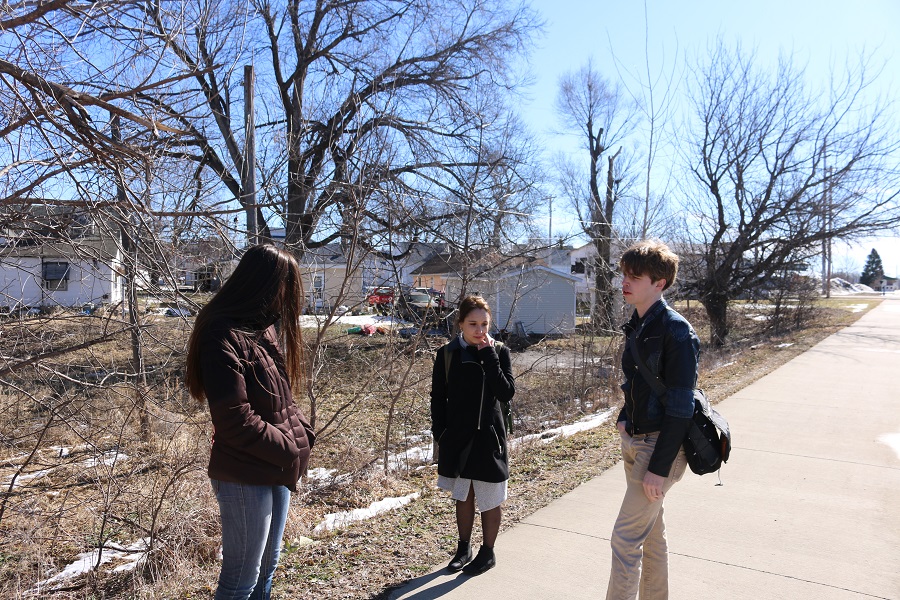 Drake students, from left, Caitlin Ryan, Shanna McCormack and Taylor Rhimes consider ways stormwater runoff from the Raccoon River Valley Trail could be managed during their walking tour Friday of the downtown cultural district.