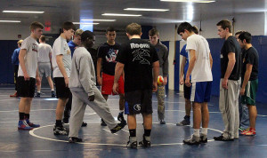 Gisaveri Niyibizi lifts the ball as Perry wrestlers, managers and coaches play a game resembling a cross between hackey-sack and dodgeball in the Perry wrestling room Monday. Any person who controlled the ball, in air, three times could then grab it, forcing others to scatter pell-mell as they tried to avoid being thrown at.