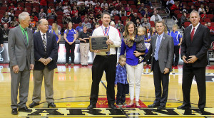 Perry boys varsity basketball head coach Ned Menke receives the Character Counts Coach of the Year award at halftime of a Class 4A semifinal at the state tournament Friday. With Menke his wife, Meg, son Pierce (4), and daughter Brynn (1). The award was presented by, from left, Alan Beste, Executive Director of the IHSAA, Dave Herold, Chairperson of IHSAA Board of Control, Scott Raeker of Character Counts and Chuck Long from the Iowa Sports Foundation. 