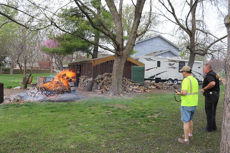 Perry Police Department Officer Wayne Schuttler, right, and Perry Volunteer Fire Department First Assistant Chief Brian Eiteman survey the progress of the fire at 2311 Iowa St. Firefighters regained control of the blaze before it damaged nearby structures. 