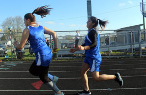 Katelyn Saldano hands off to Myka Meri for the anchor leg of the eighth grade 4x200 at the Perry Middle School Coed Relays Friday.