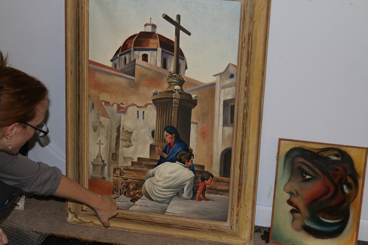 Karina Levy, left, daughter of the artist William Sturdevant, points out details in one of her father's realistic works painted in his studio in Mexico. A collection of Sturdevant's works will be permanently exhibited at the Forest Park Museum in Perry.