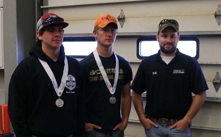 Taking second place in the Iowa Skills USA welding fabrication competition were, from left, Tory Santi and Daniel Johnson. Fellow Woodward-Granger High School welding team member Jake Yori is not pictured. DMACC VanKirk welding instructor Kyle Harding, right, congratulated the medal winners.