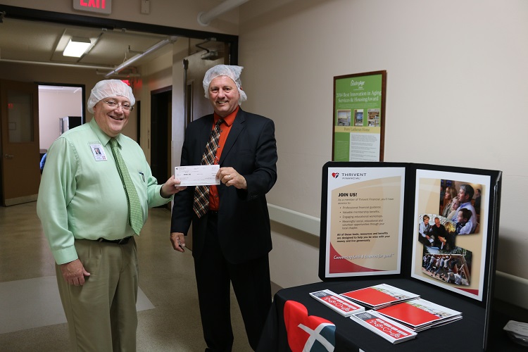 Dr. Randy McCaulley, organizer of the Meals from the Heartland event Wednesday, accepts a $500 grant check from Alan Metz of Thrivent Financial, one of the event's sponsors.