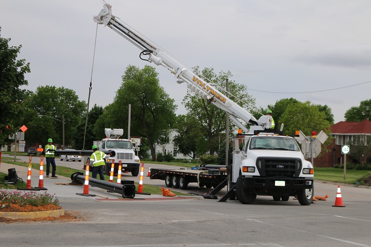 With curbs and storm-sewer intakes finished, Voltmer Electric workers raise new stoplights at the intersection of Iowa Highway 144 and Willis Avenue in Perry.