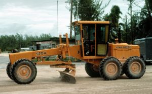 A motor grader crowns up and pulls in granular surface roadways.