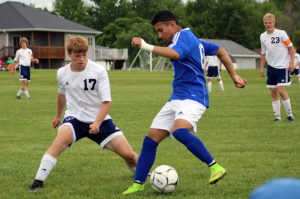 Perry junior Jesus Rodriguez tries to play the ball around a Hudson defender.