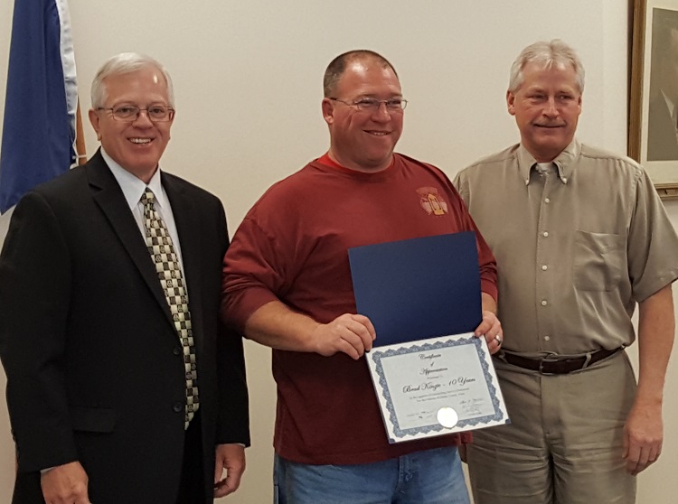 Brad Kinzie, center, was presented a certificate of appreciation last week for his 10 years of service in the Dallas County Secondary Roads Department. Dallas County Supervisor Kim Chapman, left, and Supervisor Brad Golightly presented Kinzie with the certificate.