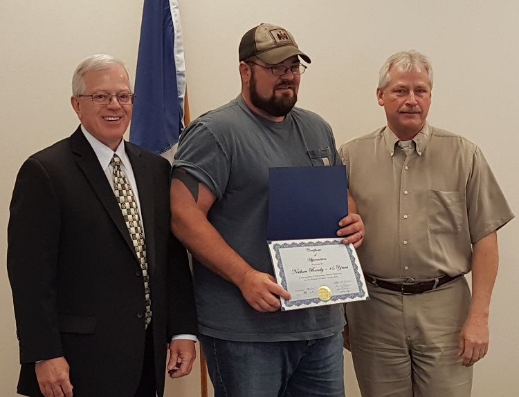 Nate bandy, center, was presented a certificate of appreciation last week for his 15 years of service in the Dallas County Secondary Roads Department. Dallas County Supervisor Kim Chapman, left, and Supervisor Brad Golightly presented Bandy with the certificate.