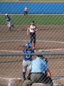 Rachel Kinney singles up the middle in the first inning, advancing Sid Vancil (middle) from second to third base.
