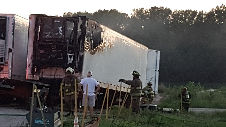 Jon Peters, in white, examines the damage to a Tyson tractor trailer that caught fire about 9 p.m. at Peters Service Center on Perry's west side.