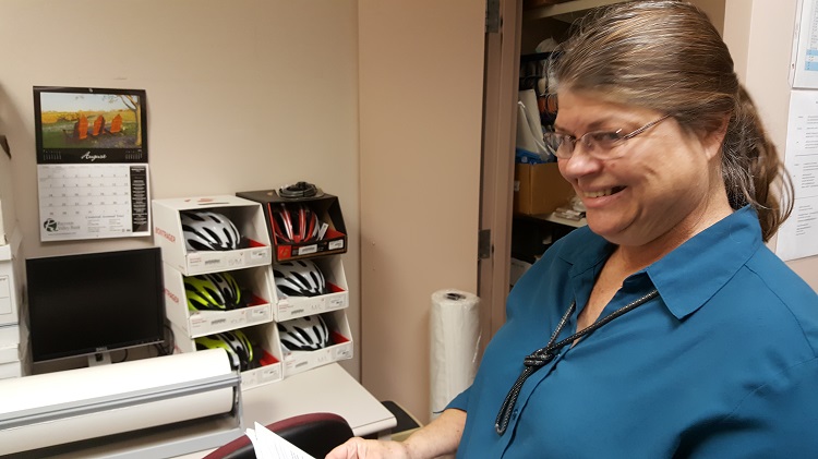 "Safety first," says Perry Public Library Director Mary Murphy as she catalogs the bicycle helmets that form part of the gear in the new Book-A-Bike program.