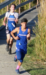 Mario Cruz heads to the final hill in the varsity race.