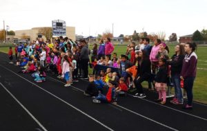 PACES students and staff gather on Kaufman Track at Dewey Field Wednesday. The students were walking laps to raise funds as part of the national "Lights on Afterschool" program.