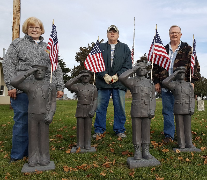 Perry Historic Preservation Commission members, from left, Jeanette Peddicord, John Palmer and Gary Martin temporarily placed for soldier statues at Violet Hill Cemetery in Perry. Each soldier represents a branch of the U.S. armed forces.