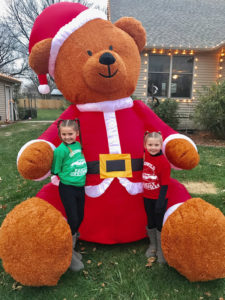 Eva (left) and Lucy Fleshner pose with Santa Bear outside their Woodward home. Photo submitted.